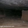 A dark cave with a very low ceiling.  It is impossible to stand in there, however people must have lived (or at least prepared food) in it as evidenced from the grinding stones carved into the rock floor.